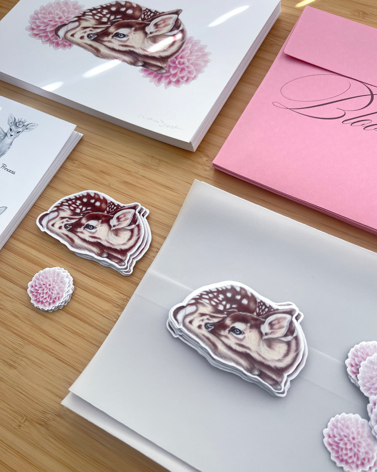 'The Bloom Edition October 2026' 
The edition includes a pink envelope with brown script, a vellum sleeve with floral sticker seal, a fawn & dahlia art print, a fawn sticker and printed studio note