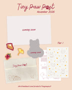 The 'Tiny Paw Post' November 2026, shown on a beige background. The set includes an illustrated card, a cream envelope with burgundy lettering, and several die-cut stickers.